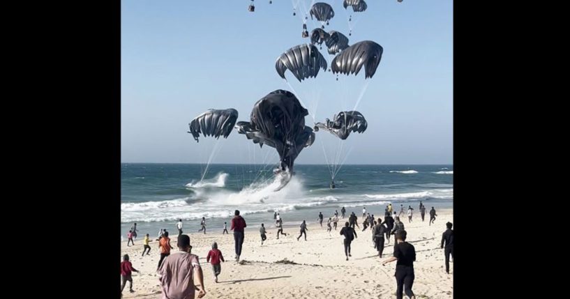 This image grab from an AFPTV video shows Palestinians running toward parachutes attached to food parcels, air-dropped from U.S. aircrafts on a beach in the Gaza Strip on March 2.