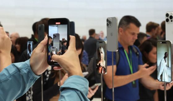 An attendee takes a picture of the new iPhone 15 Pro during an event at the Steve Jobs Theater at Apple Park on Sept. 12 in Cupertino, California.