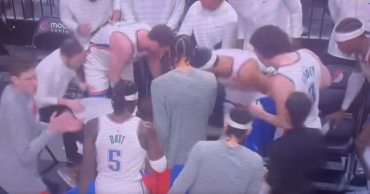 Players from the Oklahoma City Thunder crowd around player Bismack Biyombo after he collapsed suddenly during a timeout in their game against the Portland Trail Blazers on Wednesday.