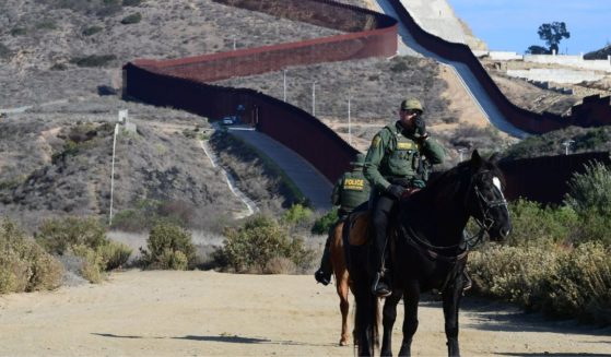 U.S. Border Patrol police on horseback monitor the U.S.-Mexico border fence in Imperial Beach, California, on Nov. 7, 2021.