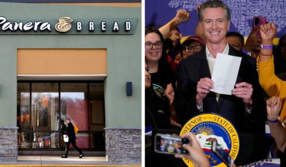 Calif. Gov. Gavin Newsom signs the fast food bill surrounded by fast food workers at the SEIU Local 721 in Los Angeles on Sept. 28.