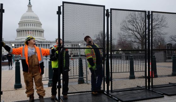 Eight-foot-tall steel fencing is put up around the U.S. Capitol in Washington on Wednesday, the day before President Joe Biden was to deliver the State of the Union address.