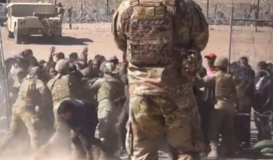 Texas National Guard members are seen being overrun by illegal immigrants trying to force their way across the southern border at El Paso, Texas.