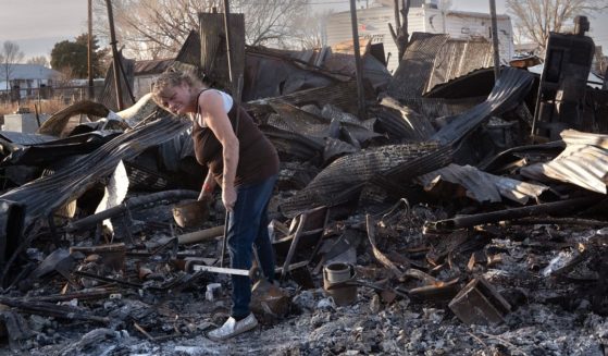 Melissa Jones cleans debris from her father's property after a garage, carport and shop near Stinnett, Texas, were destroyed by the Smokehouse Creek fire on Sunday.