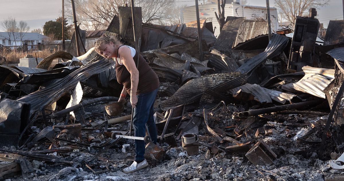 Melissa Jones cleans debris from her father's property after a garage, carport and shop near Stinnett, Texas, were destroyed by the Smokehouse Creek fire on Sunday.