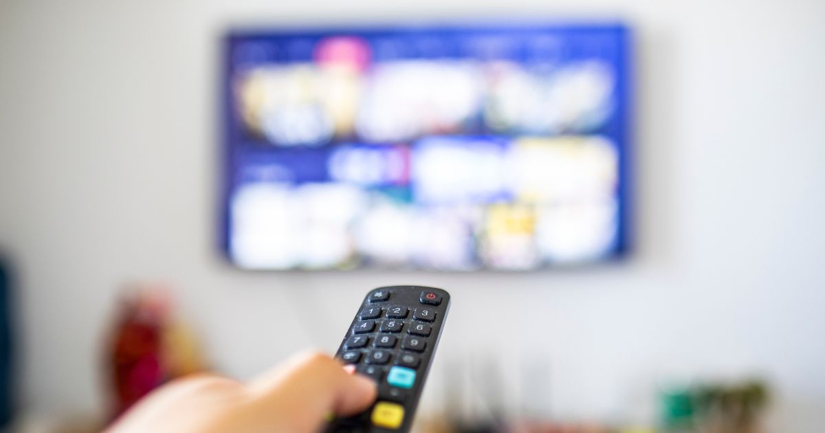A remote control pointed at a television.