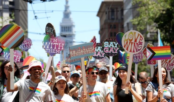 Marchers carry signs during the 52nd Annual San Francisco Pride Parade and Celebration in San Francisco, California, on June 26, 2022.