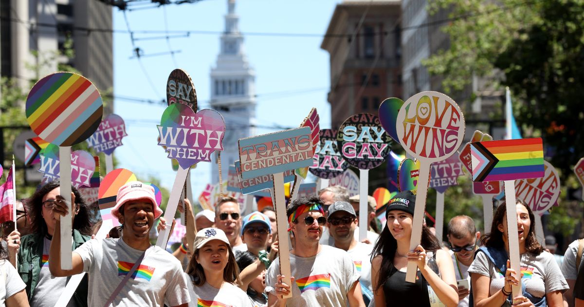 Marchers carry signs during the 52nd Annual San Francisco Pride Parade and Celebration in San Francisco, California, on June 26, 2022.