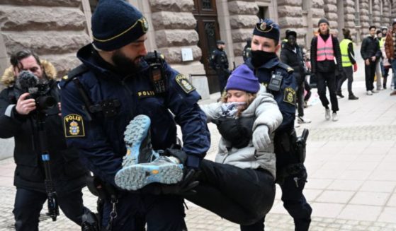 Swedish climate activist Greta Thunberg is carried away by police after staging a sit-in outside the Swedish parliament, the Riksdagen, to demonstrate for climate action, March 13, in Stockholm, Sweden.