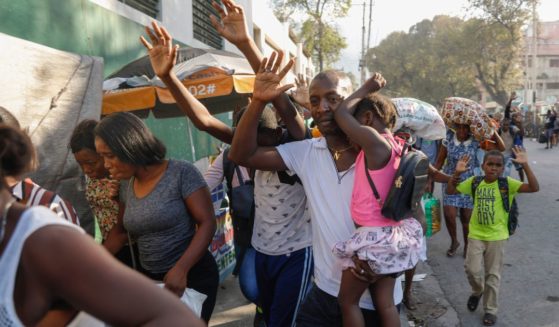 Residents flee their homes during clashes between police and gang member at the Portail neighborhood in Port-au-Prince, Haiti, on Thursday.