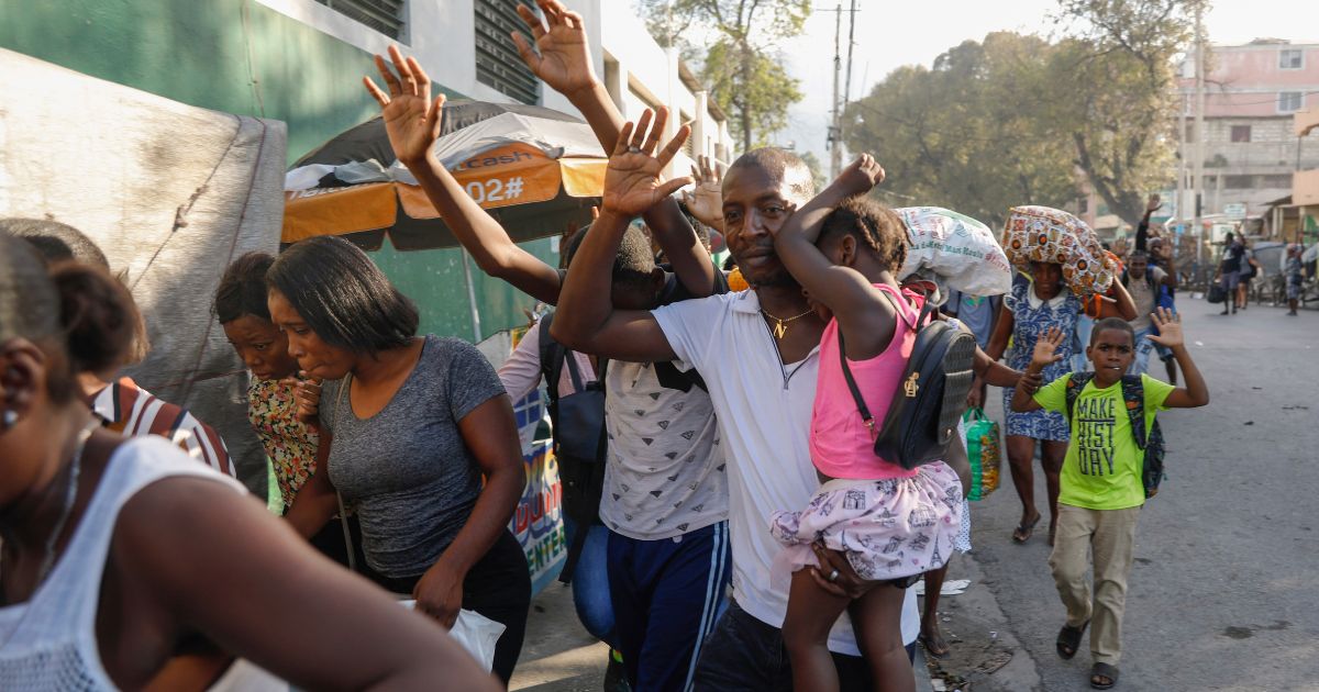 Residents flee their homes during clashes between police and gang member at the Portail neighborhood in Port-au-Prince, Haiti, on Thursday.