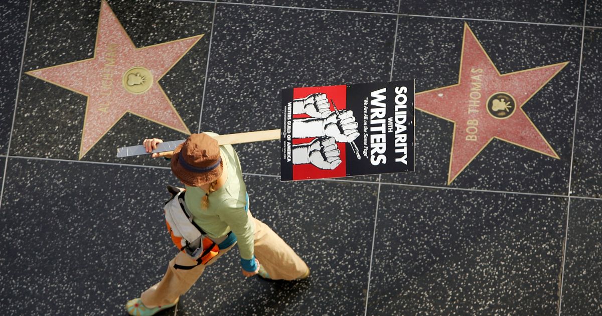 A member of the Hollywood writers' strike walking past the Hollywood Walk of Fame in 2007.