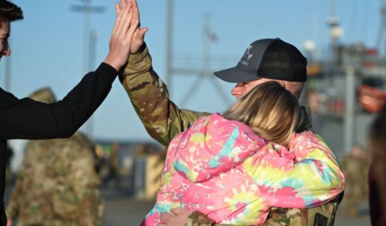 US Army Chief Warrant Officer Jason West gives a high five to his son, Devyn, 15 (left) as he gets a hug from his daughter, Alexys, 9, before his ship departs the Joint Base Langley-Eustis during a media preview of the 7th Transportation Brigade deployment in Hampton, Virginia, on Tuesday. The Brigade is deploying to the Middle East to assist in the multinational humanitarian aid corridor for Gaza.