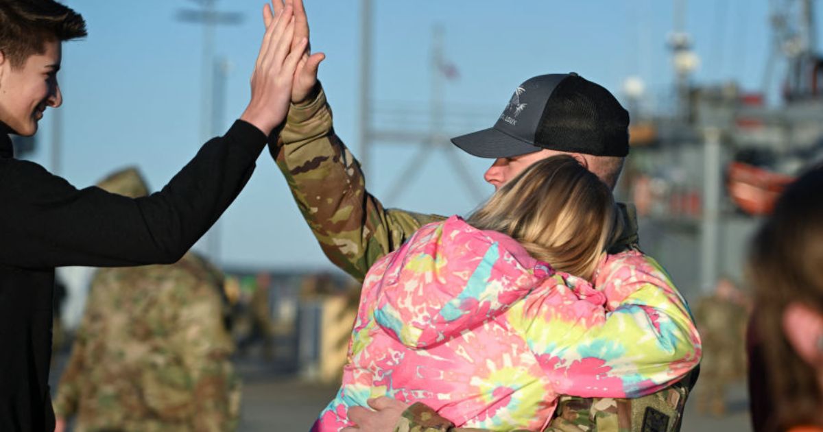 US Army Chief Warrant Officer Jason West gives a high five to his son, Devyn, 15 (left) as he gets a hug from his daughter, Alexys, 9, before his ship departs the Joint Base Langley-Eustis during a media preview of the 7th Transportation Brigade deployment in Hampton, Virginia, on Tuesday. The Brigade is deploying to the Middle East to assist in the multinational humanitarian aid corridor for Gaza.