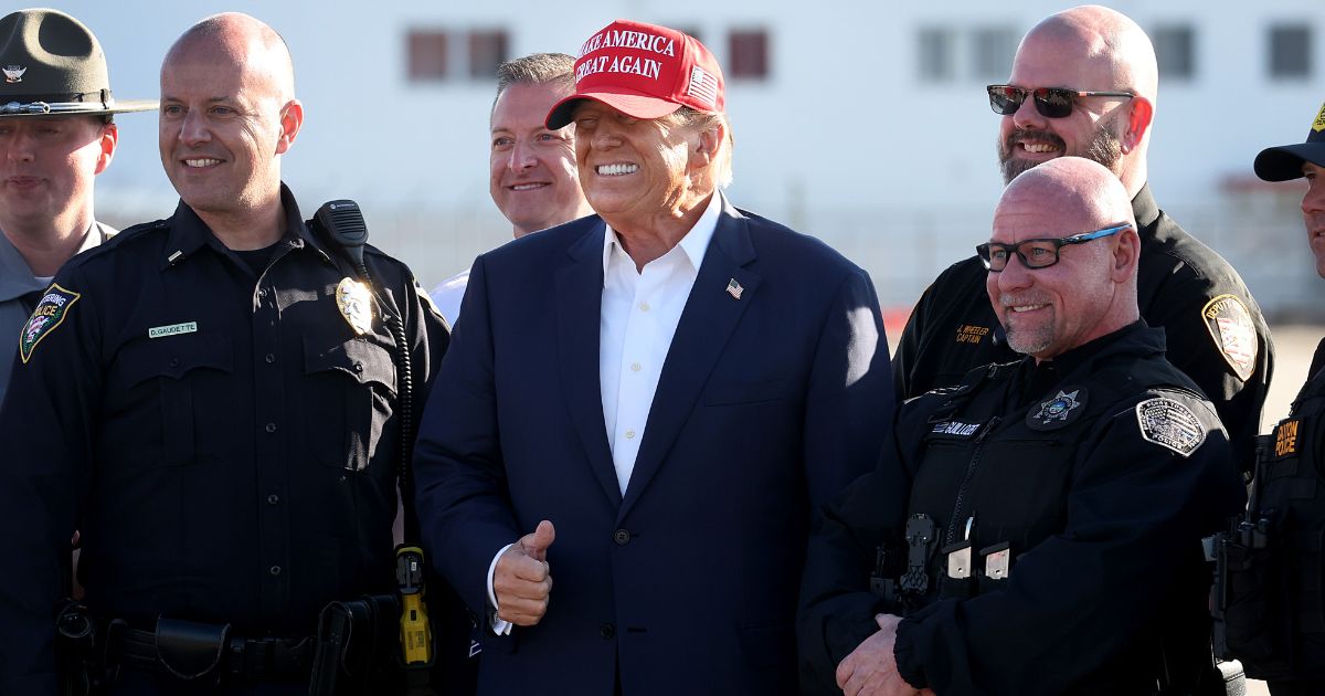 Republican presidential candidate and former President Donald Trump poses with law enforcement officers following a rally at the Dayton International Airport in Vandalia, Ohio, on Saturday.