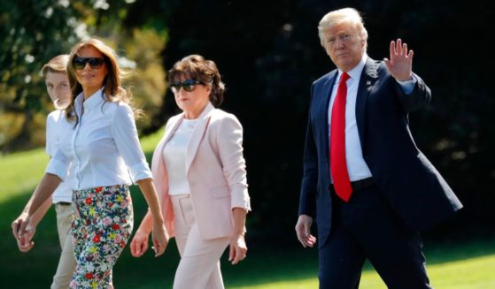 President Donald Trump, right, waves as he walks out, with from l-r., son Barron, first lady Melania Trump, and Amalija Knavs, mother of first lady Melania Trump, as they walk across the South Lawn of the White House in Washington, June 29, 2018.