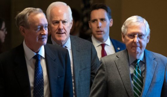 Sens. Josh Hawley, second from right, and Mitch McConnell, right, walk to the Senate chamber at the U.S. Capitol in 2020. Hawley and McConnell currently are at odds over the Radiation Exposure Compensation Act.