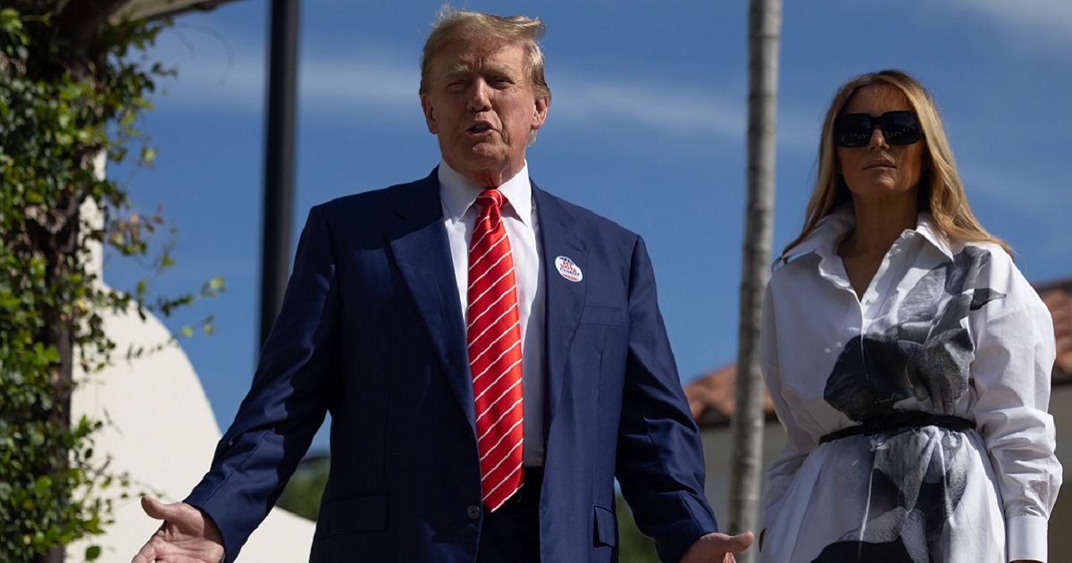 Former U.S. President Donald Trump stands with former first lady Melania Trump as he addresses reporters Tuesday outside a polling station in Palm Beach, Florida.