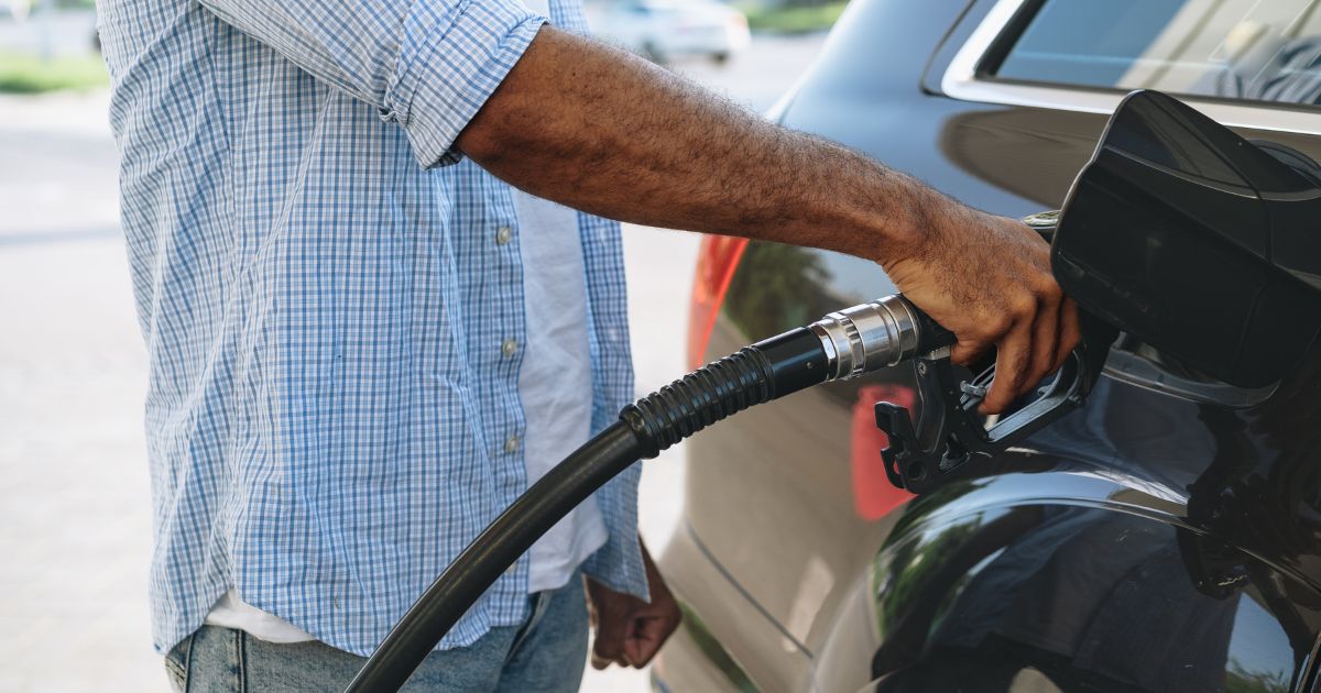 A stock photo shows a man pumping gas into his car.