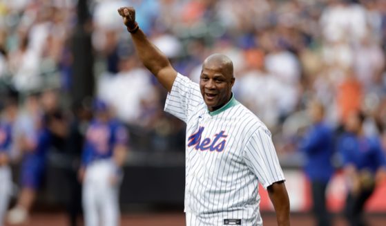 Former New York Met Darryl Strawberry raises his fist in the air after throwinga ceremonial first pitch at Citi Field on July 26, 2022 in New York City.