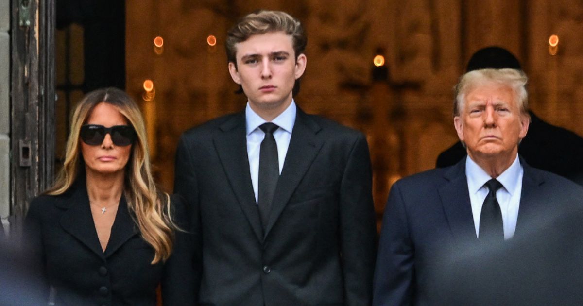 Former President Donald Trump, right, stands with his wife, Melania Trump, and their son, Barron Trump, as the coffin carrying the remains of Amalija Knavs, the former first lady's mother, is carried into the Church of Bethesda-by-the-Sea for her funeral in Palm Beach, Florida, on Jan. 18.