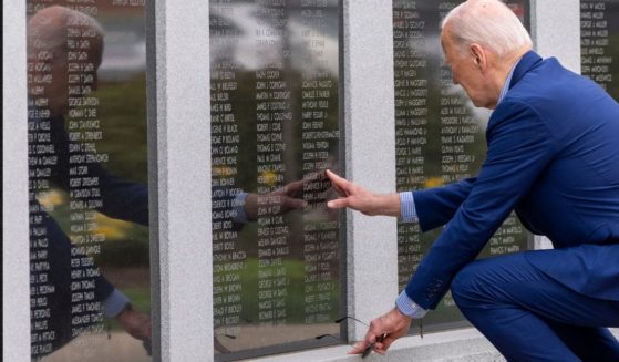 President Joe Biden reaches to touch the name of his uncle Ambrose J. Finnegan, Jr., on a wall at a Scranton World War II memorial, Wednesday in Scranton, Pennsylvania. News outlets contradicted Biden's insinuation that his uncle was eaten by cannibals.