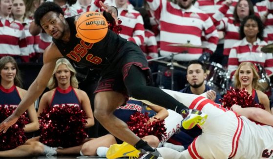 Southern California guard Bronny James, left, scrambles for the ball with Arizona guard Pelle Larsson during the first half of an NCAA college basketball game in the quarterfinal round of the Pac-12 tournament March 14, 2024, in Las Vegas.
