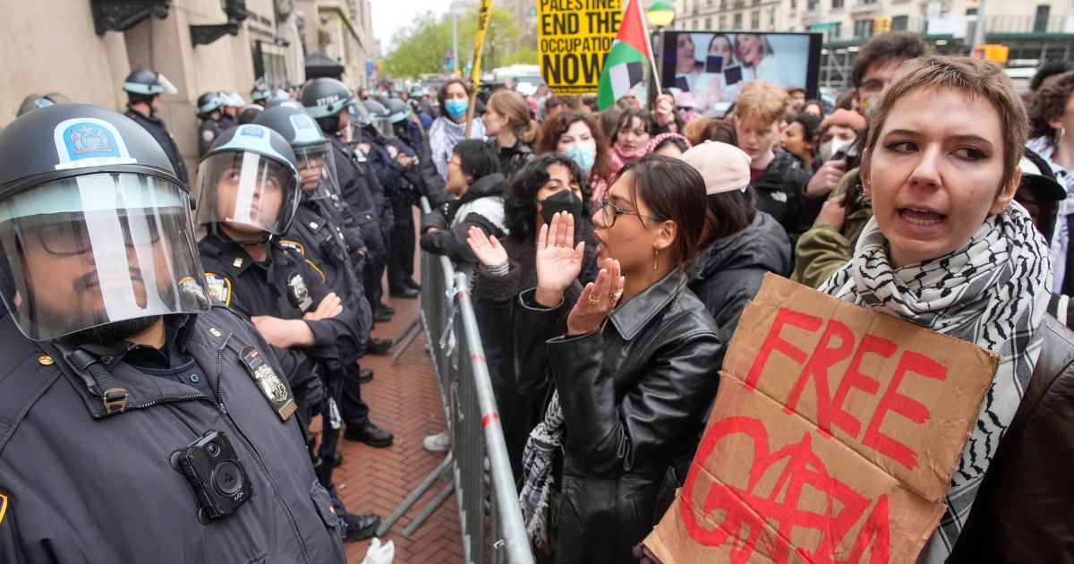police in riot gear facing off against protesters at Columbia University