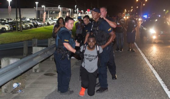 activist DeRay McKesson mugging for the camera while being arrested