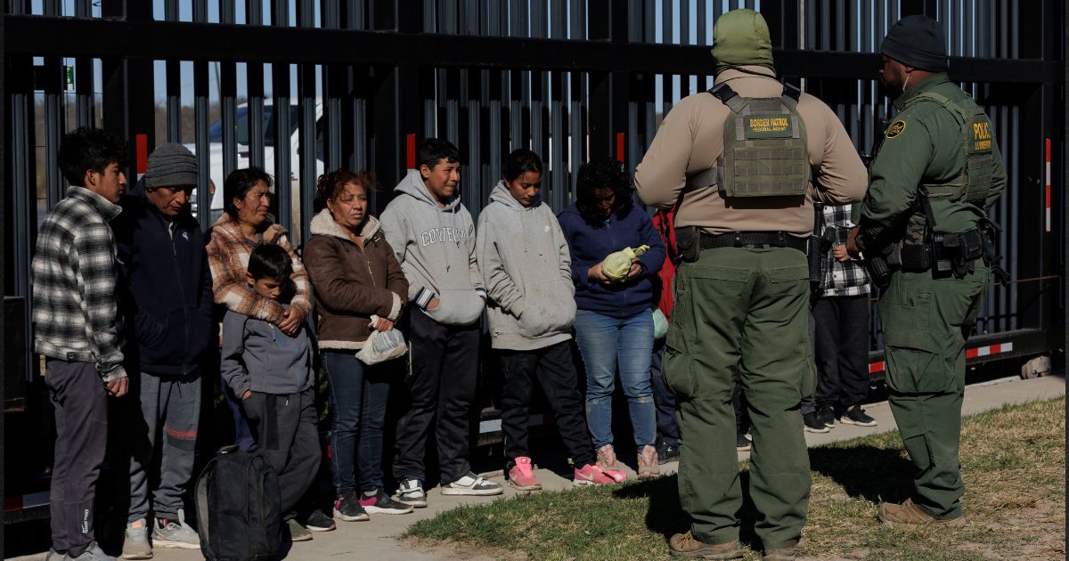 U.S. Border Patrol agents guard migrants who crossed into the U.S. in Eagle Pass, Texas, in a file photo from Feb. 4.