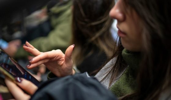 A subway passenger reads her iPhone in New York City on March 27.