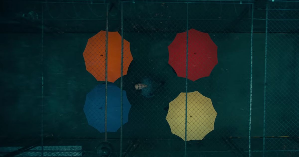 The titular character from the upcoming film "Joker: Folie à Deux" surrounded by colorful umbrellas.