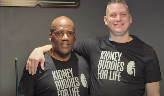 James Harris, Jr., left, and Russ Redhead pose in their "Kidney Buddies for Life" T-shirts after Redhead donated a kidney to Harris, his friend and former rival.