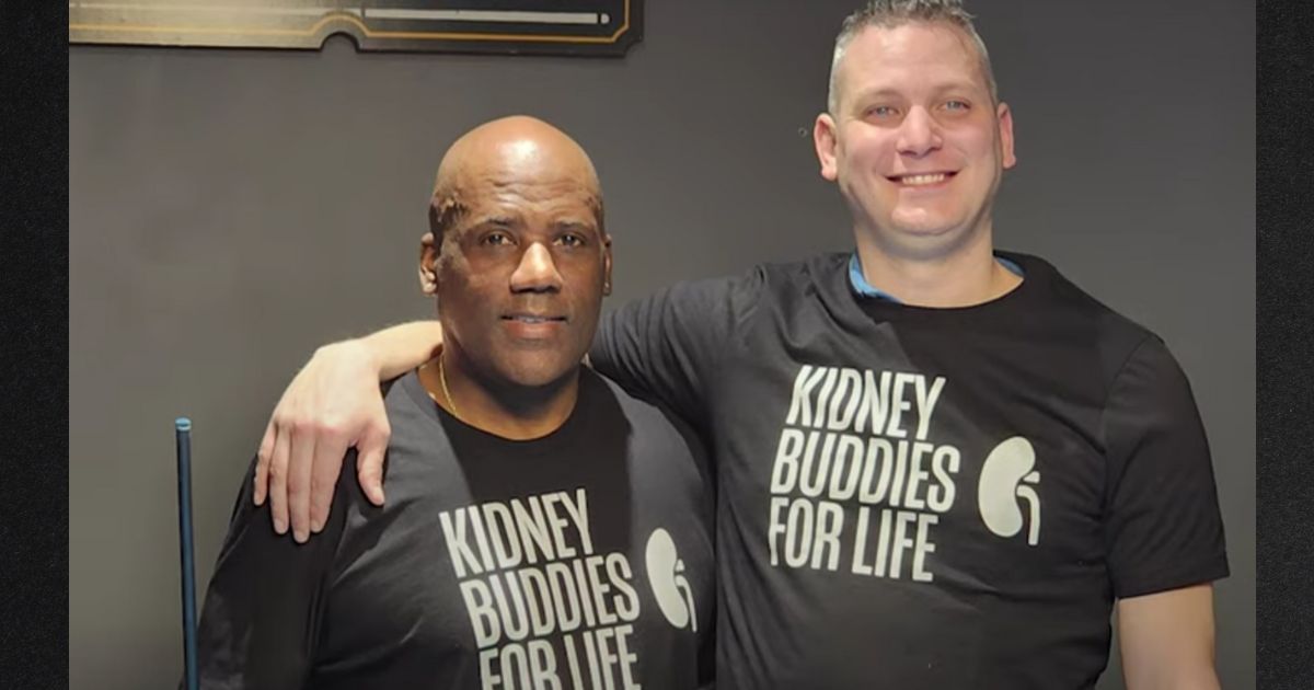 James Harris, Jr., left, and Russ Redhead pose in their "Kidney Buddies for Life" T-shirts after Redhead donated a kidney to Harris, his friend and former rival.