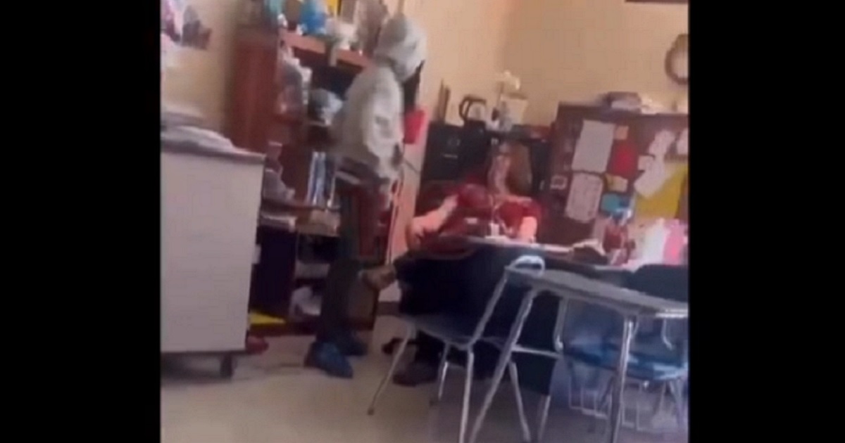 A student hovers over a teacher before delivering a second slap in a classroom confrontation on April 15 in Winston-Salem, North Carolina.