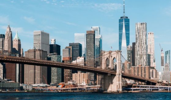 This stock photo shows the New York City skyline with the Brooklyn Bridge and Manhattan Downtown.