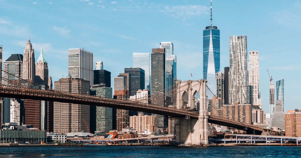This stock photo shows the New York City skyline with the Brooklyn Bridge and Manhattan Downtown.