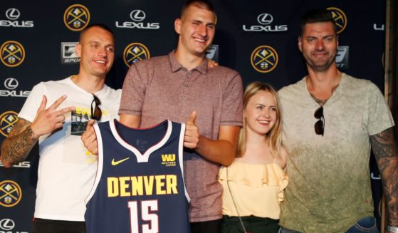 Nikola Jokić, center left, poses with Nemanja Jokić, left, Natalija Macesic, center right, and Strahinja Jokić, right, during a news conference to outline a contract extension in Denver, Colorado, on July 9, 2018.