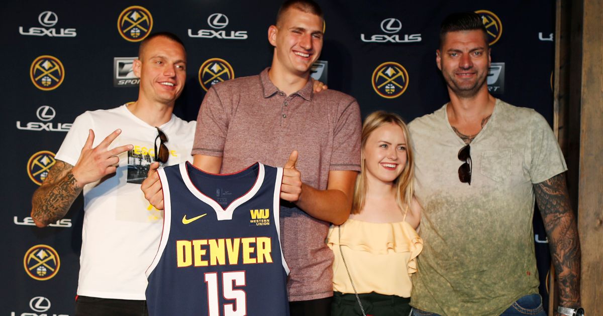 Nikola Jokić, center left, poses with Nemanja Jokić, left, Natalija Macesic, center right, and Strahinja Jokić, right, during a news conference to outline a contract extension in Denver, Colorado, on July 9, 2018.