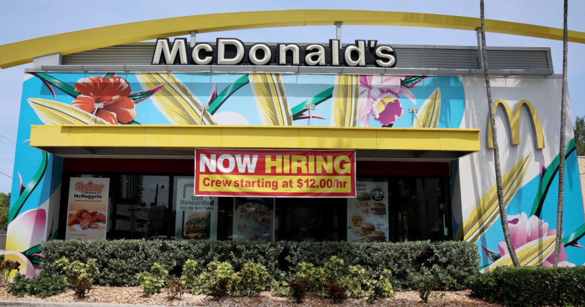 A 'Now Hiring' sign is posted outside of a McDonald's restaurant in Miami.