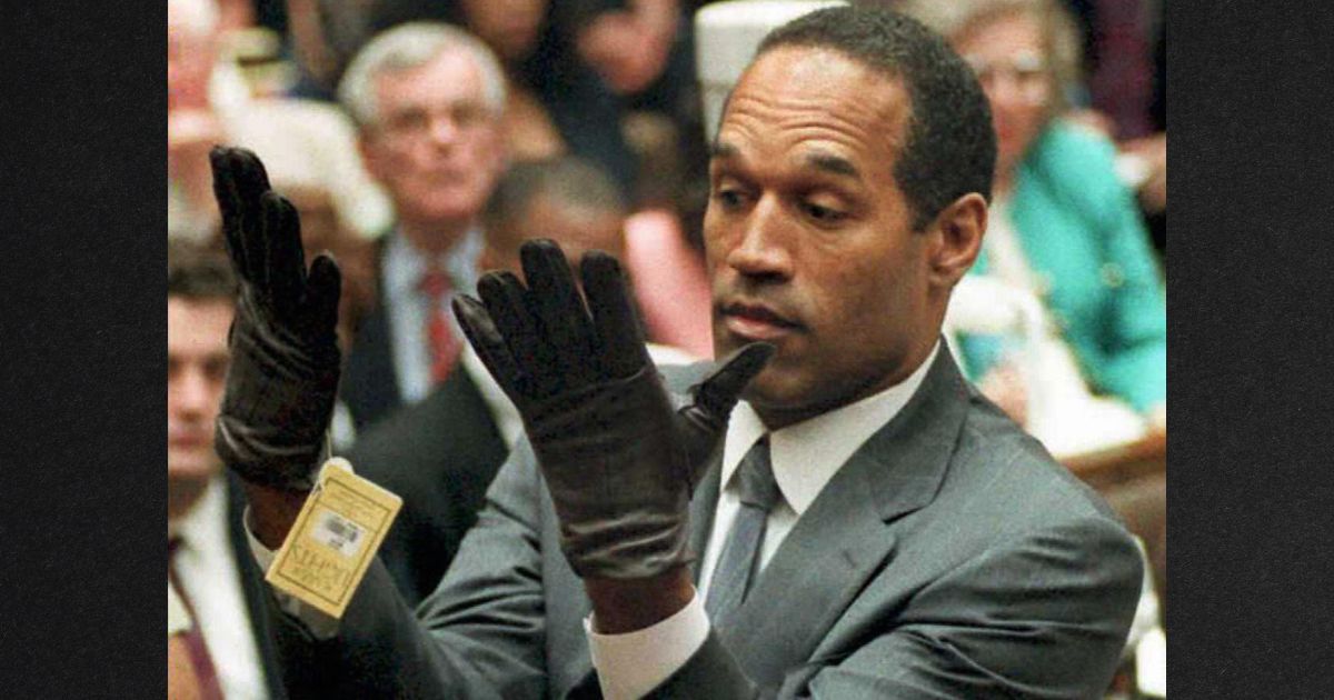 O.J. Simpson is seen in a file photo from June 21, 1995, looking at a new pair of Aris extra-large gloves that prosecutors had him put on during his double-murder trial in Los Angeles.
