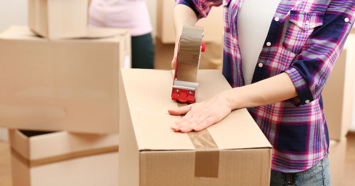 A stock photo shows people packing boxes before a move.