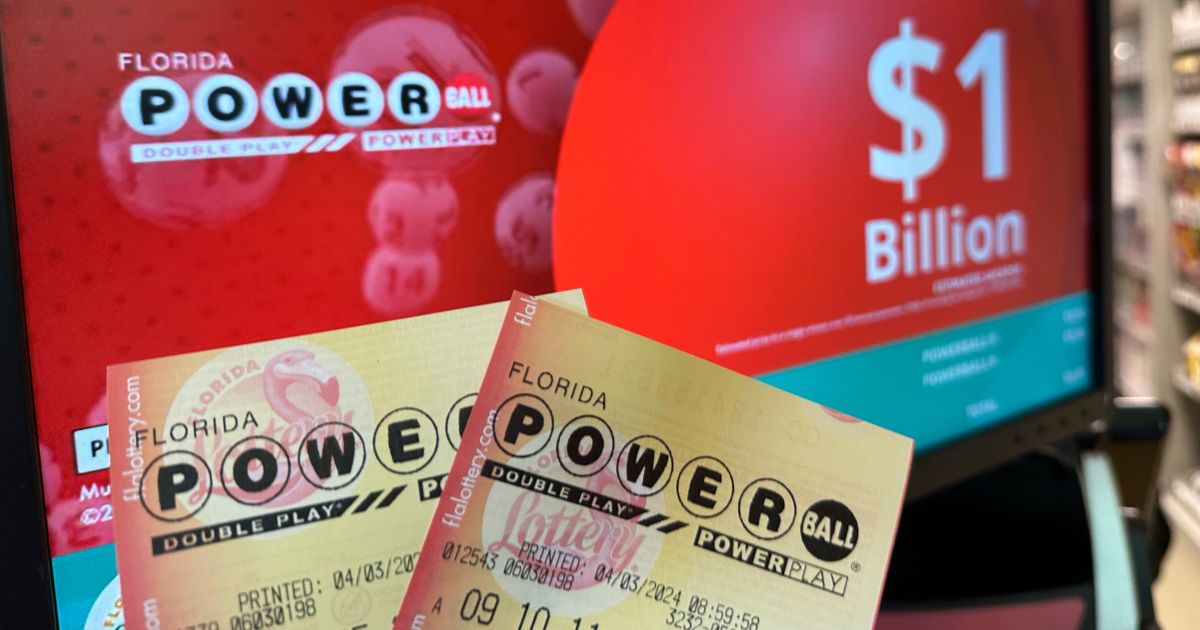Powerball tickets are shown in front of a screen displaying the estimated Powerball jackpot in Surfside, Florida, on Wednesday.