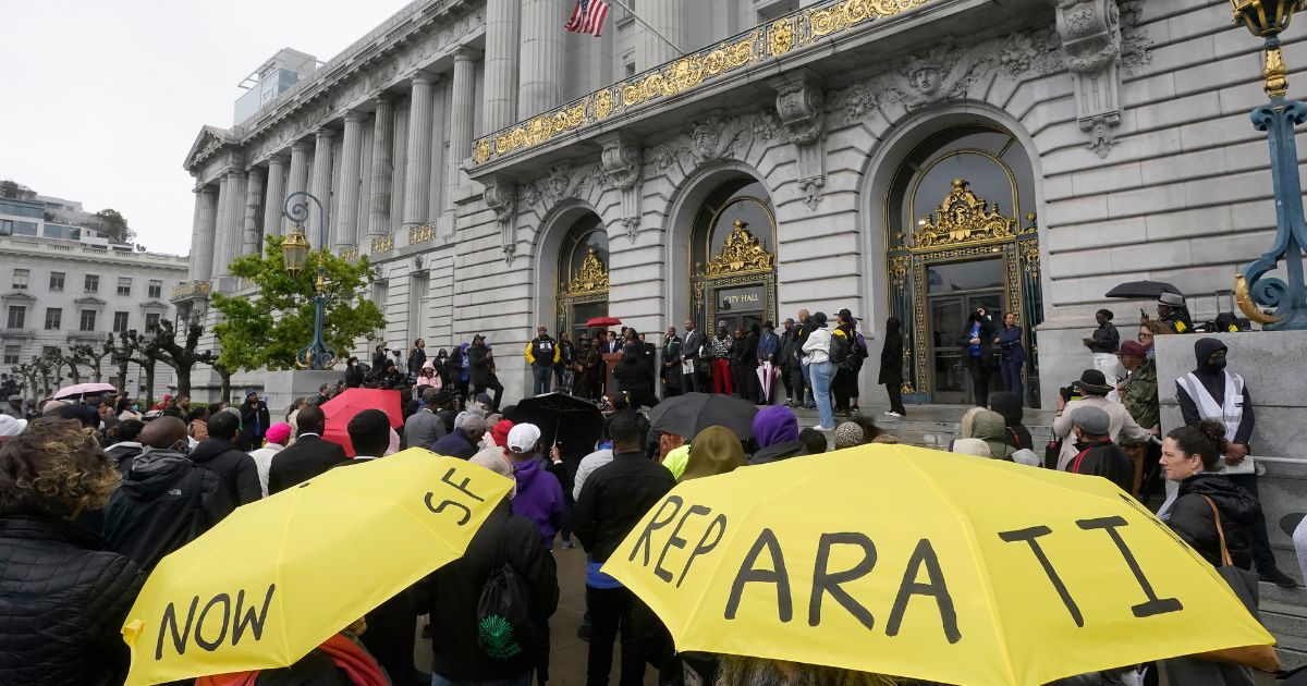 A crowd listens to speakers at a reparations rally outside of City Hall in San Francisco, in a file photo from March 14, 2023.