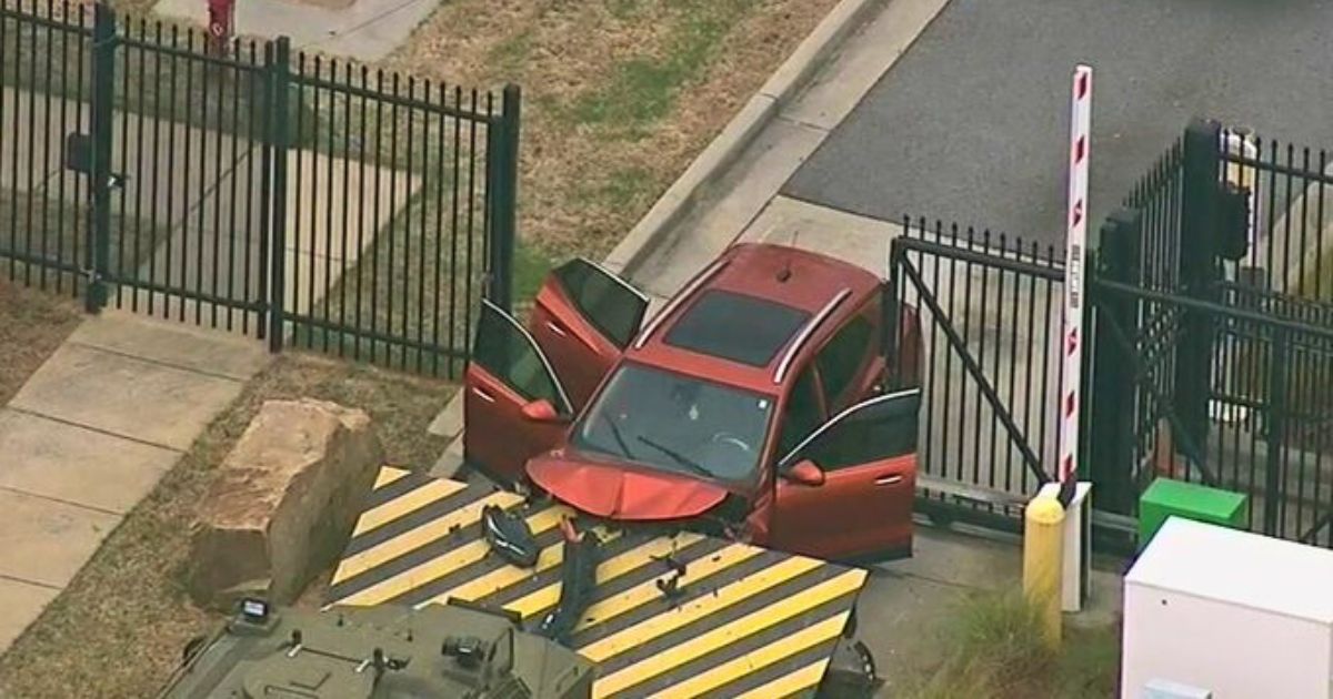 An SUV is stuck in the gate of the FBI's Atlanta office on Monday.