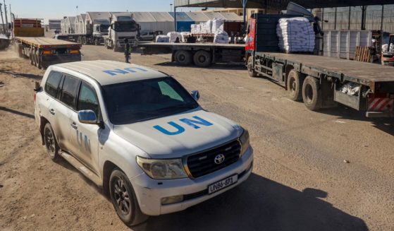 A United Nations vehicle drives past trucks delivering humanitarian aid to Gaza on Feb. 17.