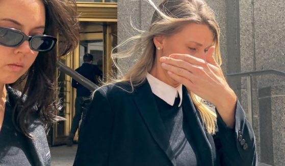 Aimee Harris, who was sentenced Tuesday for conspiracy related to selling a diary kept by President Joe Biden's daughter, covers her face as she leaves court in Manhattan.