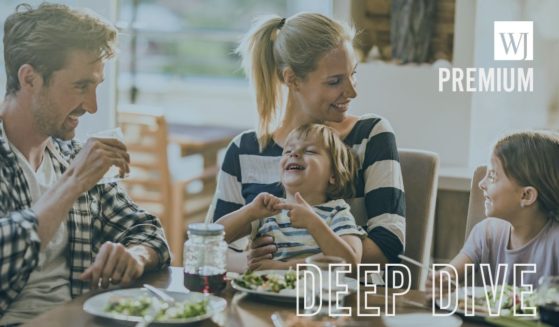 A family eats a meal together in the above stock image.
