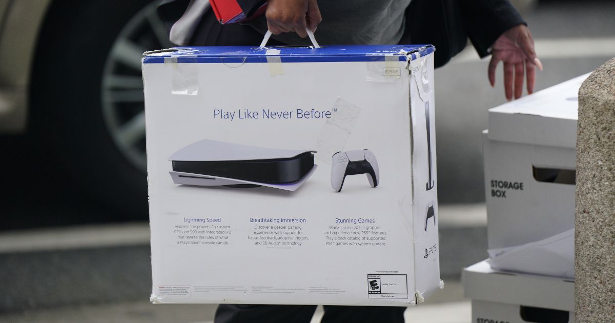 A woman carries a Playstation PS5 box as she arrives at federal court on June 27, 2023 in San Francisco, California.