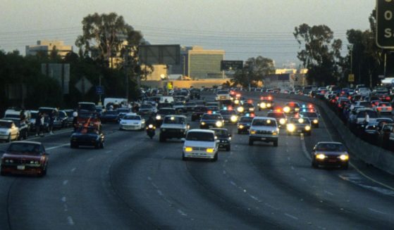 Police cars pursue the Ford Bronco driven by Al Cowlings, carrying fugitive murder suspect O.J. Simpson, on a 90-minute slow-speed car chase June 17, 1994 on the 405 freeway in Los Angeles, California.